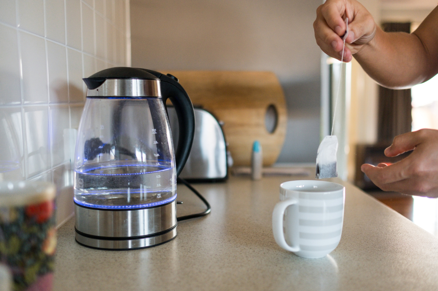 Person making tea in kitchen