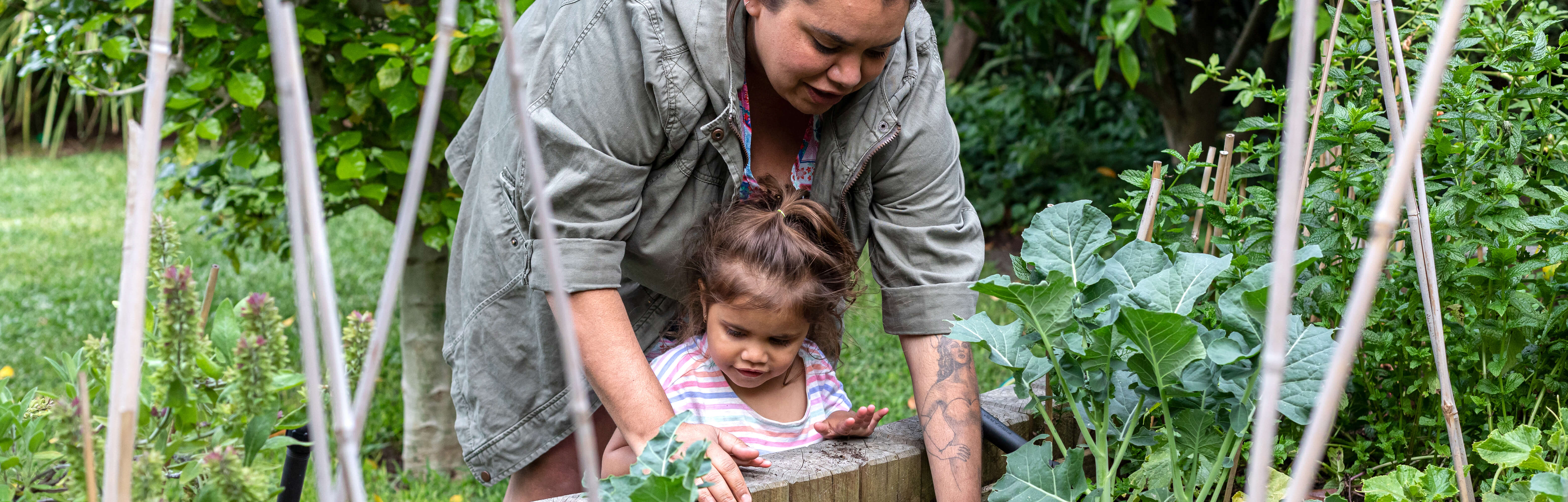 Mother and daughter tending to a vegetable garden