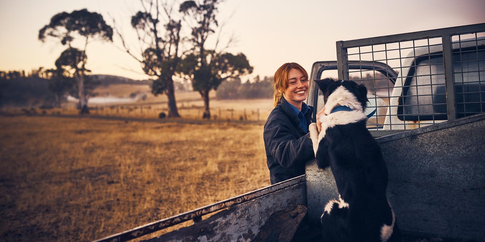 woman on country with cattledog in ute