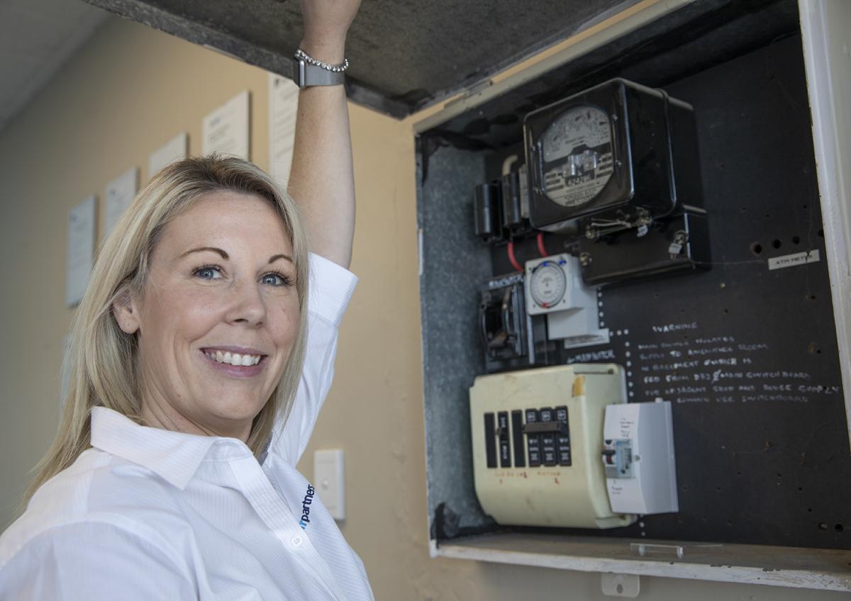 Woman standing next to energy meter