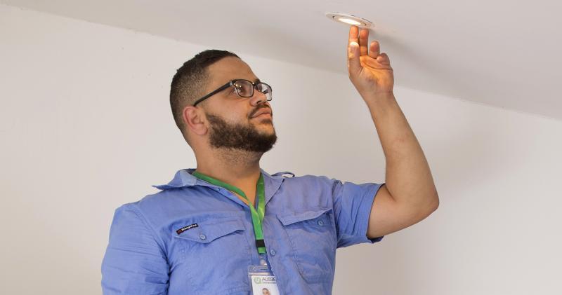 Electrician inspecting a ceiling light