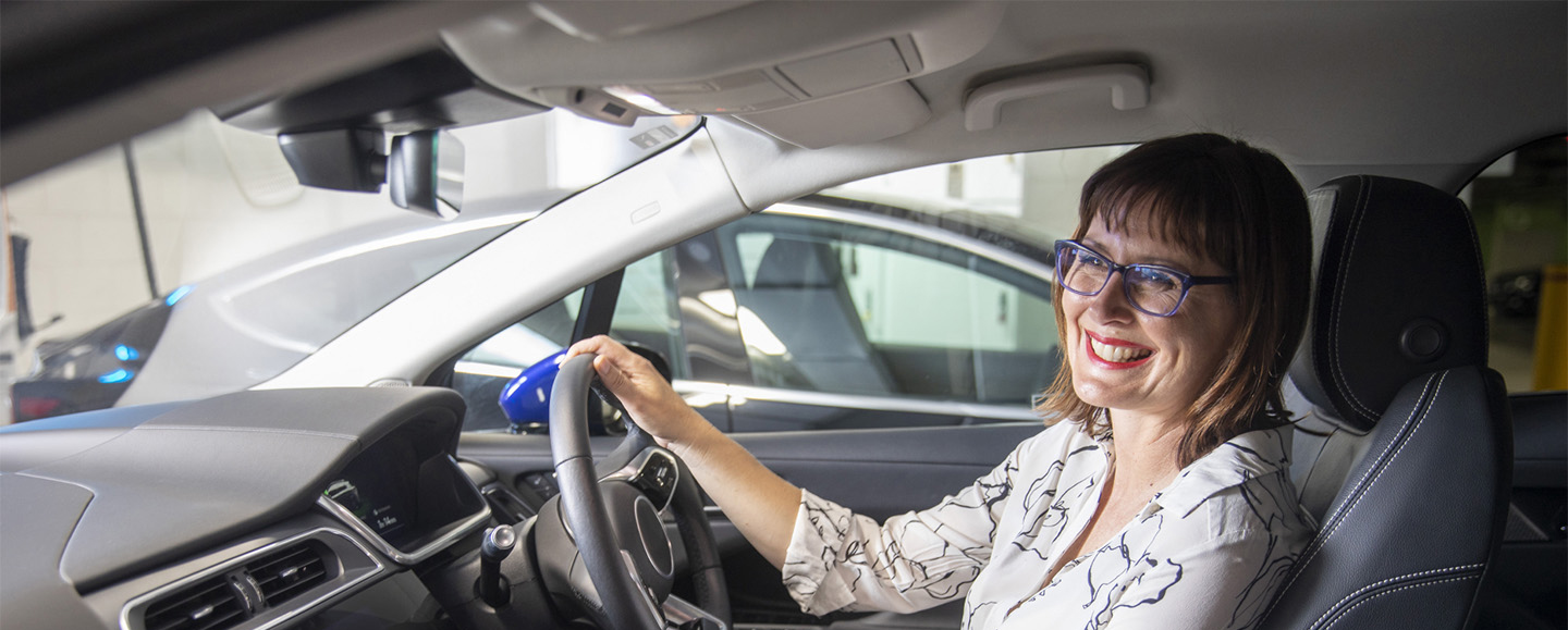 Woman smiling while sitting in electric vehicle