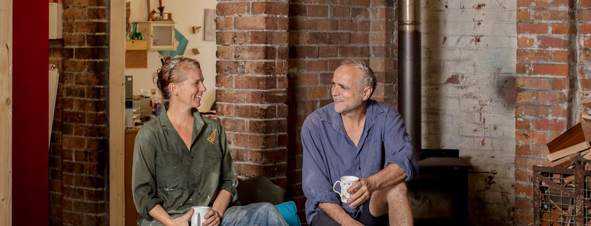 Couple having tea sitting in factory