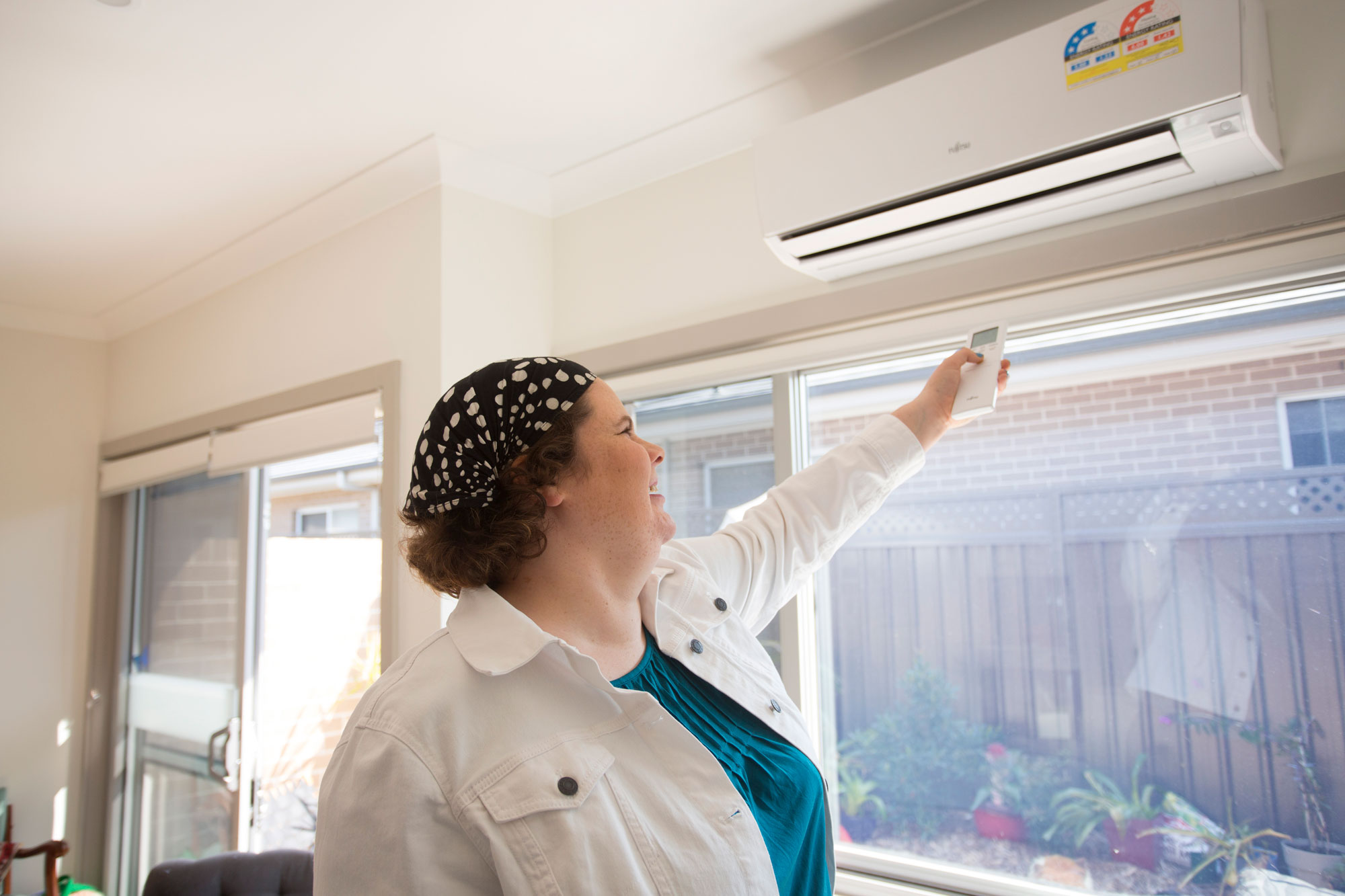 Woman operating air conditioner 