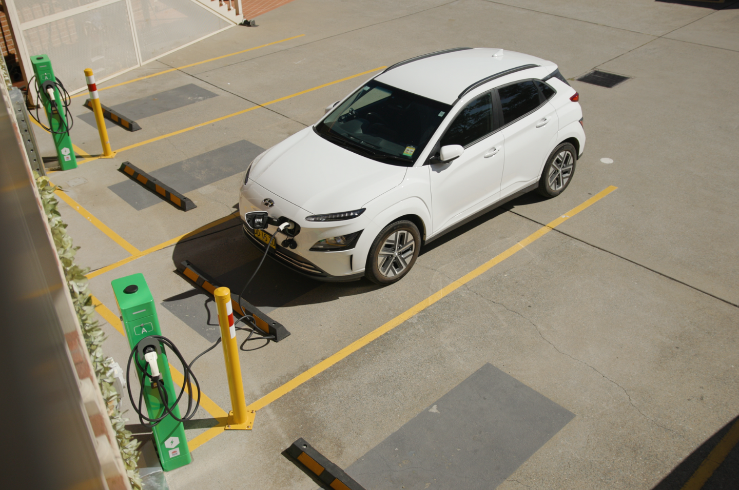 White electric vehicle parked at charging station