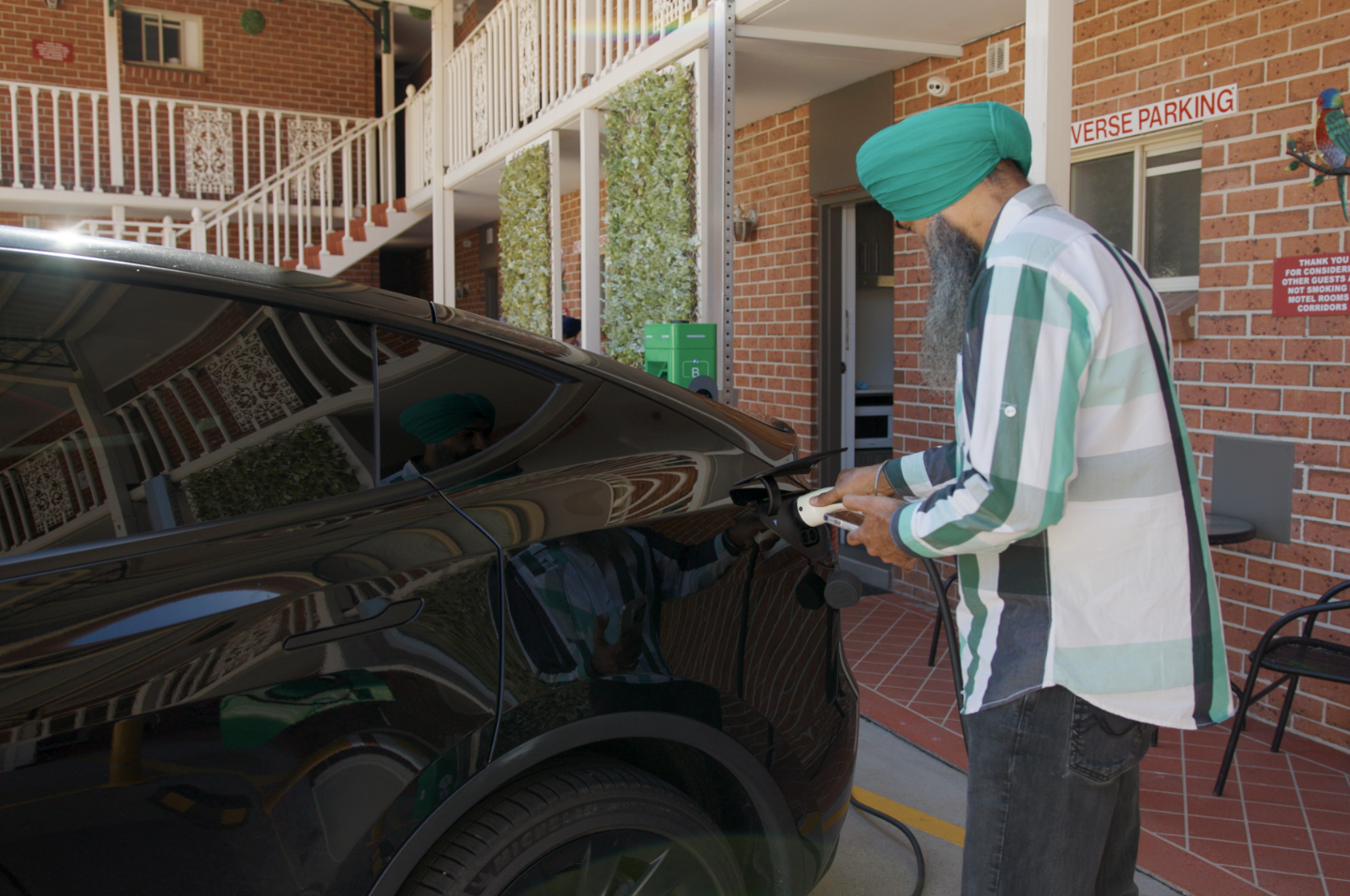 Person charging electric vehicle