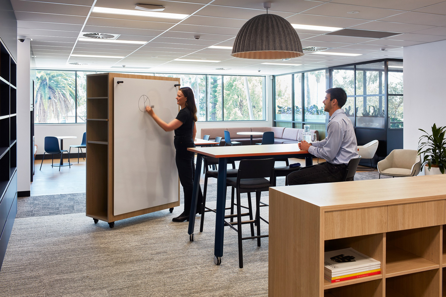 An office with two people collaborating on a whiteboard