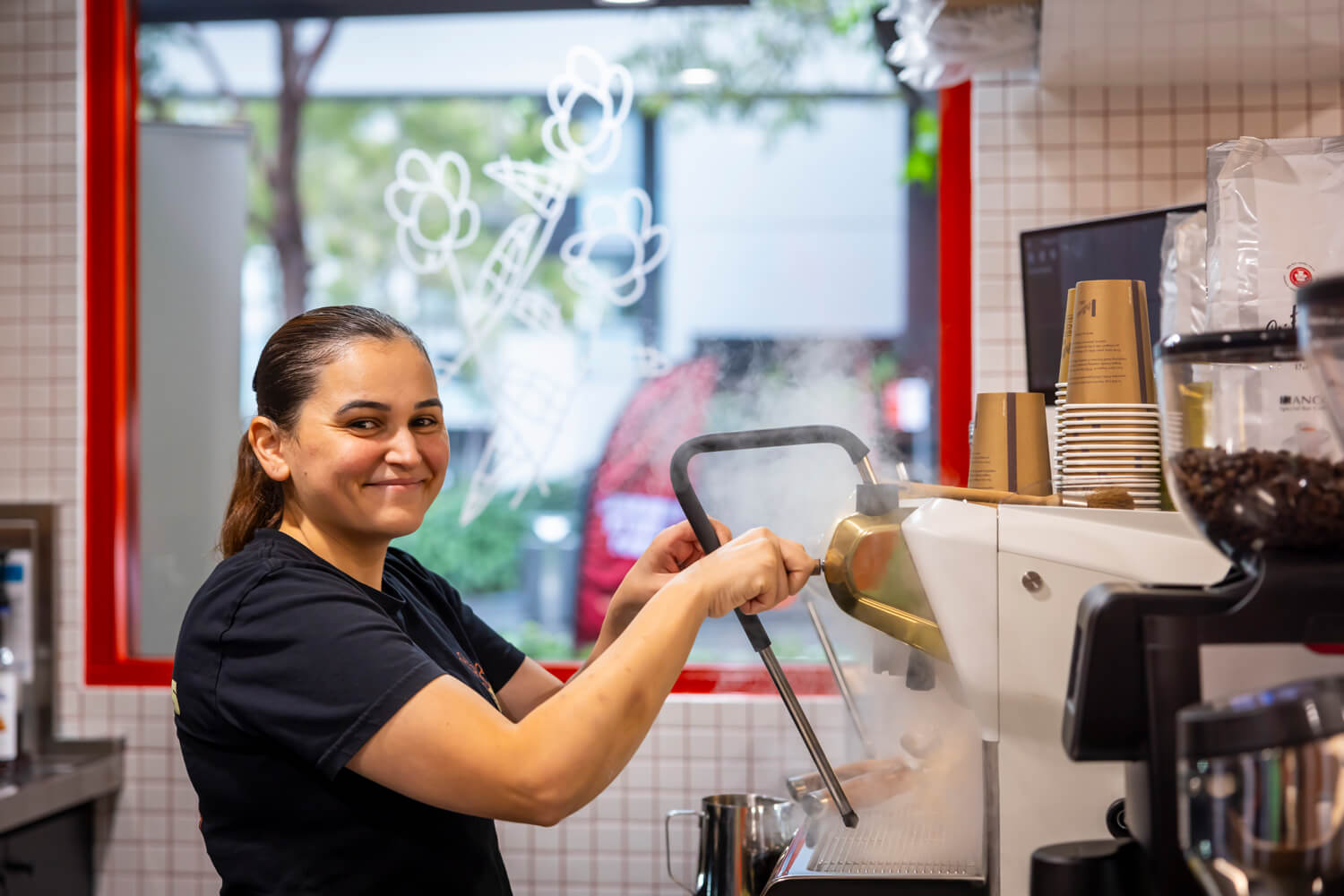 A small business owner making coffee on a machine