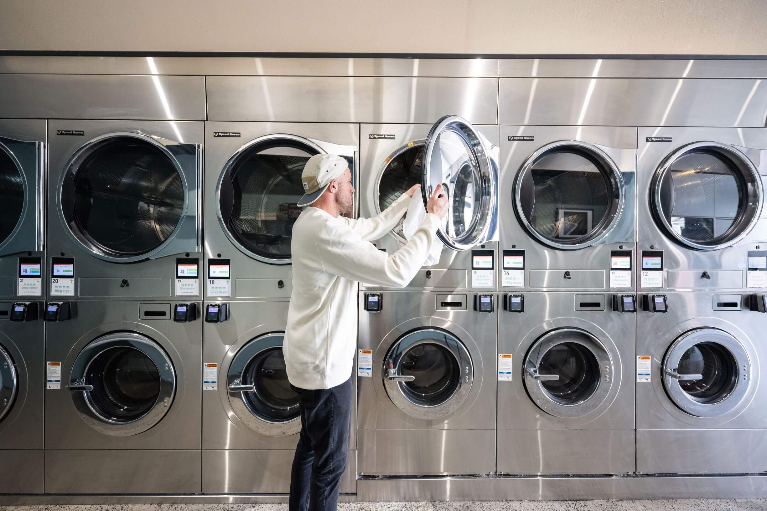 A person loading laundry into a washing machine