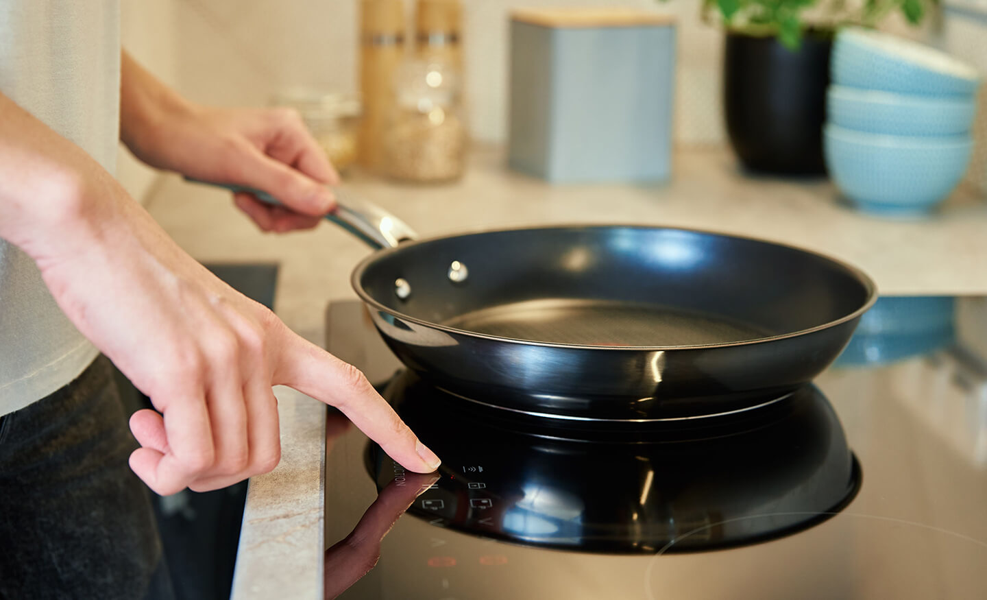 Close up of person using induction cooktop