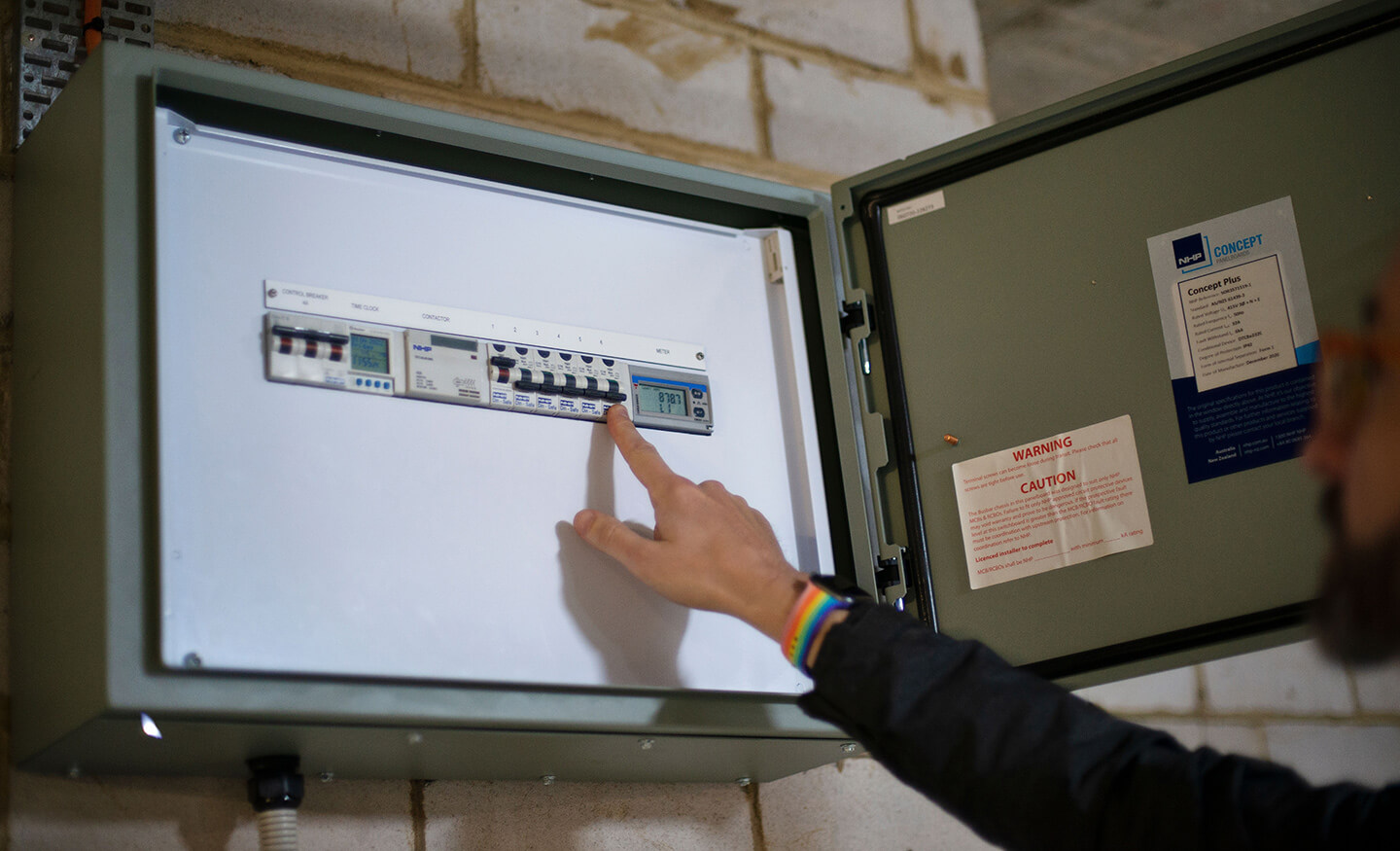 Photo of person pointing at switchboard