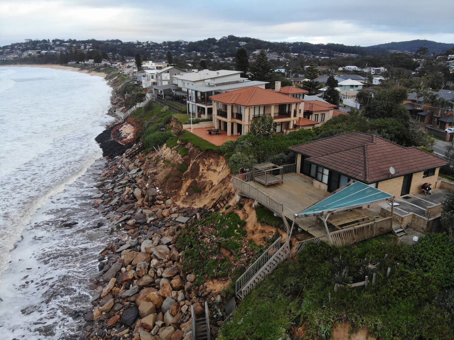 Homes at the edge of a seaside cliff