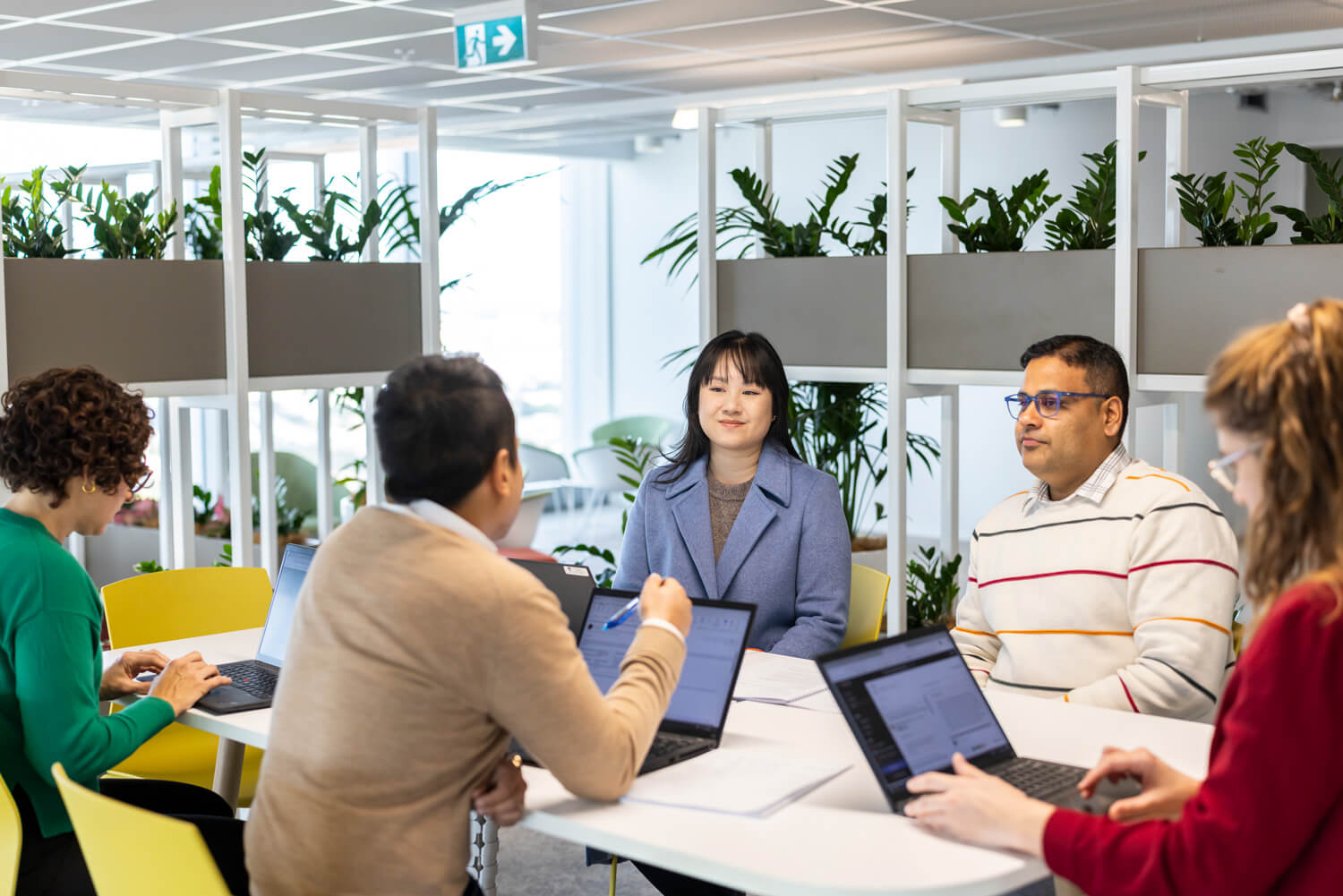 A group of people in an office setting having a meeting