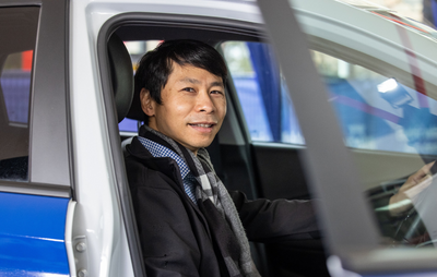 Person sitting in driver's seat of electric vehicle