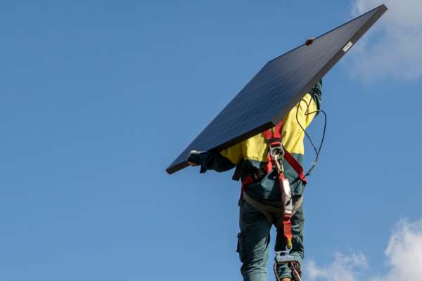 Tradesperson carrying solar panel