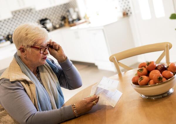 Woman reading bill in kitchen