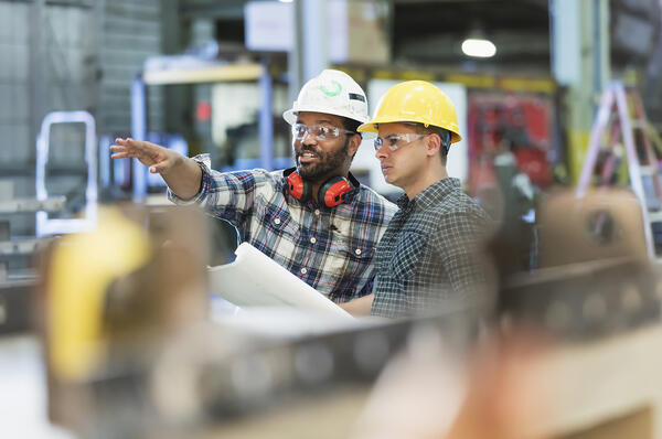 Two colleagues in protective gear, one is pointing