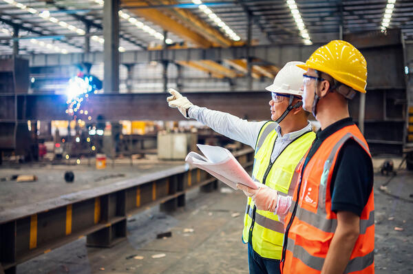 Two people working in intense industrial workshop