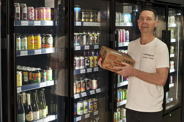 Person standing in front of fridges in bottle shop