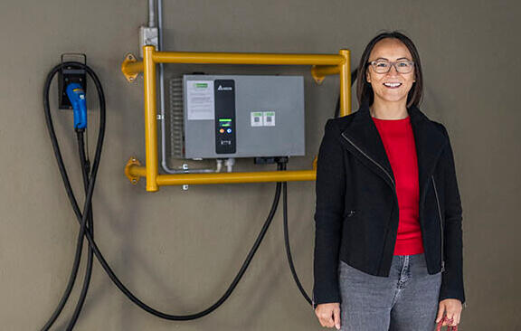 Person standing in front of electric vehicle charger