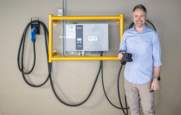 Person standing in front of electric vehicle charger