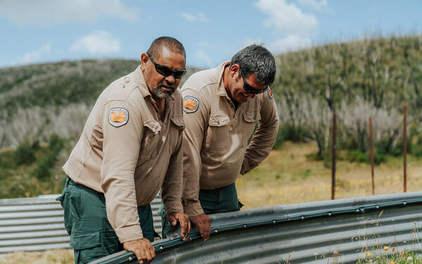 2 people in National Parks uniforms looking at garden bed