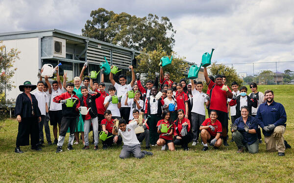 School children holding watering cans