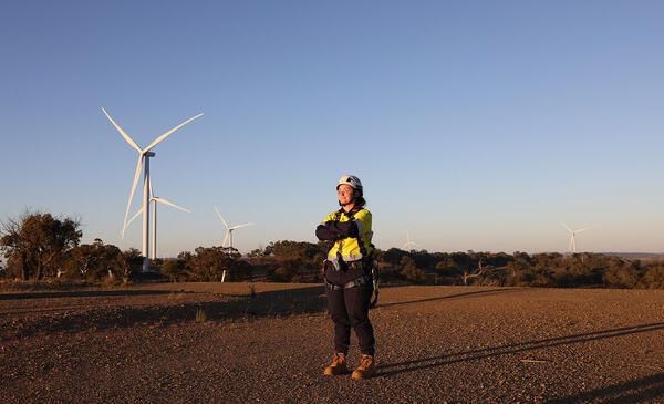 Staff member walks outside near wind turbine